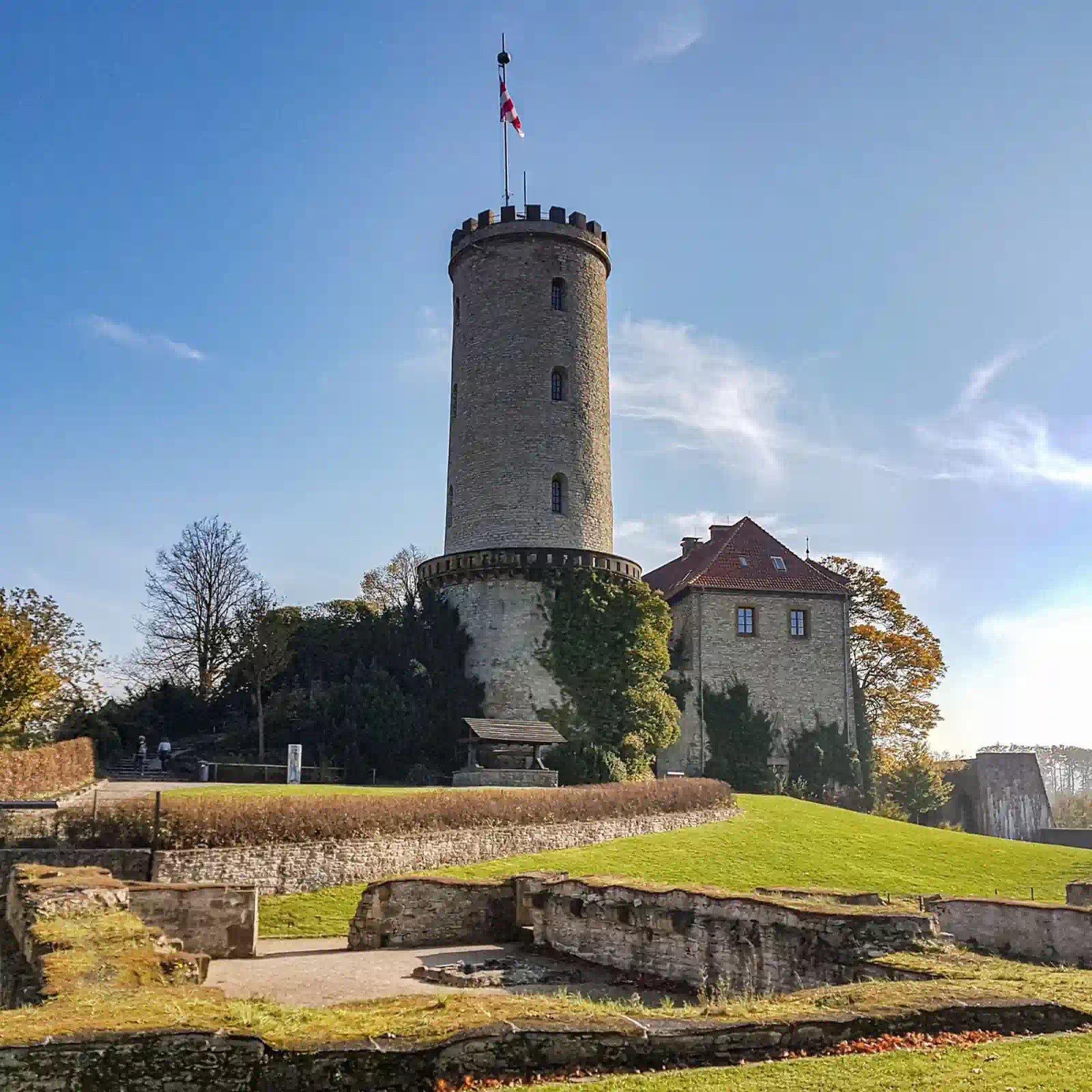 Die Sparrenburg in Bielefeld, bei sonnigem Tag und grüner Wiese.