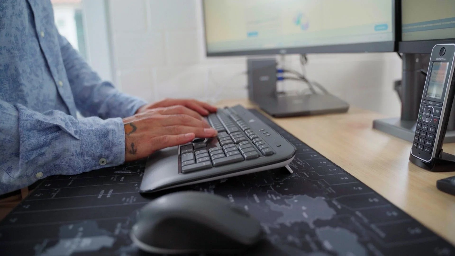 Junger Mann bedient Tastatur am ergonomischen Büroplatz
