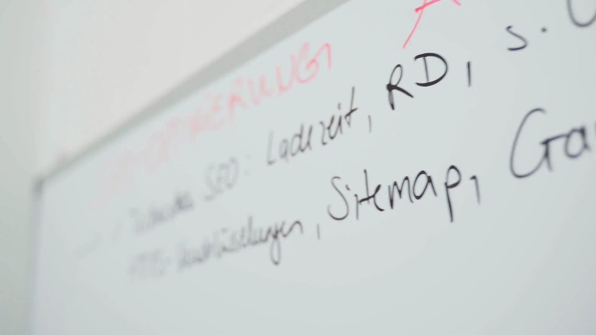 Beschriftetes Whiteboard mit SEO-Begriffen in der Farbe Schwarz und Rot