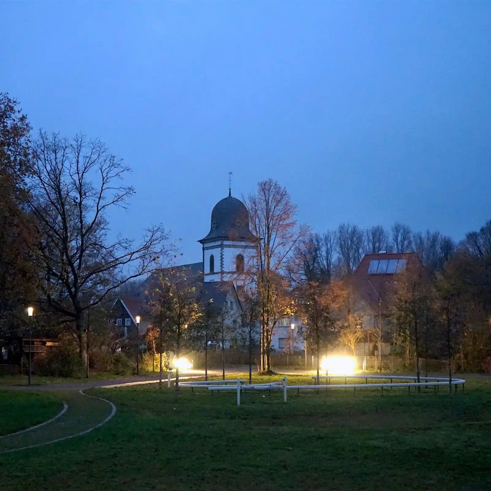 Die St. Anna Kirche in Verl bei Dämmerung, mit leuchtenden Laternen.
